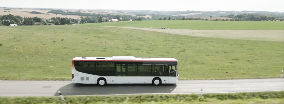 Ein Linienbus fährt über eine Landstraße.